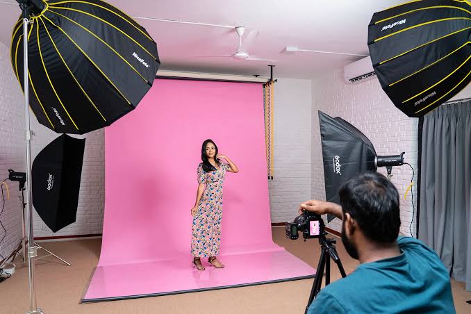Photography studio prepared with camera equipment, lighting stands, and a clean backdrop for an upcoming shoot
